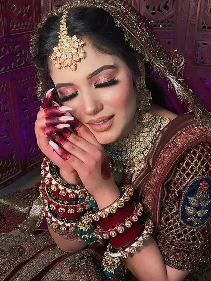 The same bride with her eyes closed, showing off the delicate pink and gold eyeshadow. This is a perfect example of a soft glam bridal eye look.
