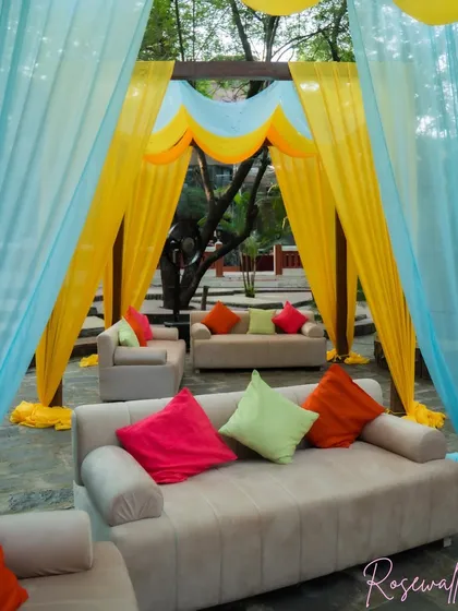 The comfortable lounge seating inside one of the colorful cabanas, adorned with bright, mismatched cushions for a playful and inviting look.