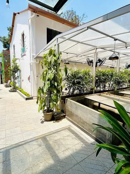 An outdoor seating area we designed for a cafe. We used a combination of tall potted plants and built-in planters to create a lush, garden-like environment that offers shade and a pleasant dining experience.