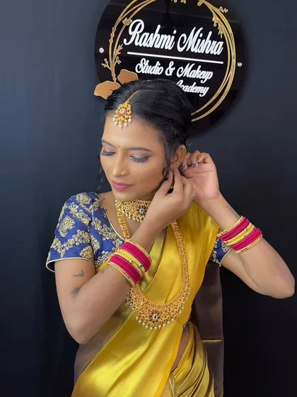 The model adjusting her earring, a candid shot that shows the intricate details of the temple jewelry.