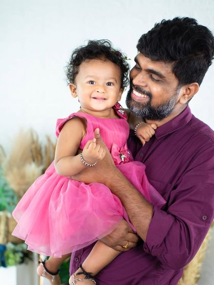 A big smile from the birthday girl, held securely in her father's arms. His proud and happy expression is just as precious.