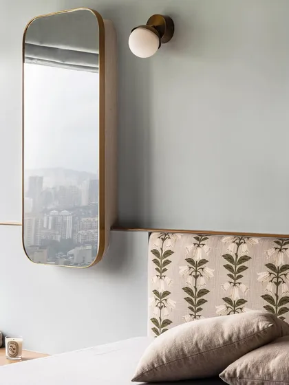 The cool blue walls of this master bedroom in Apartment 3201 create a calming lull, perfect for retiring at the end of the day. A custom floral headboard and a sleek, floating mirror add layers of texture and sophistication.