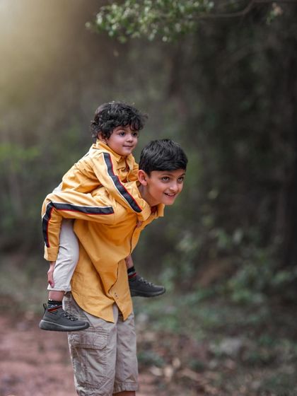 The bond between brothers is a special one. This shot of a piggyback ride through the woods is full of energy, joy, and the carefree spirit of childhood adventure.
