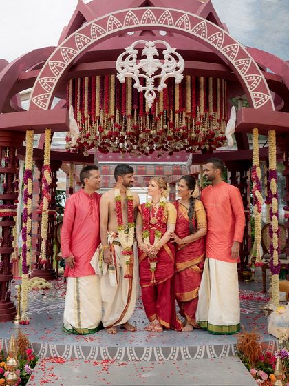 A family portrait from a beautiful Iyer wedding. The groom's traditional veshti and the groomsmen's matching drapes show how coordinated attire can bring the whole wedding party together.