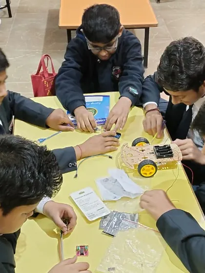 This is what hands-on learning looks like. A team of students at Lions Public School works together, intensely focused on assembling the chassis and wiring of a robotic car during one of our workshops.