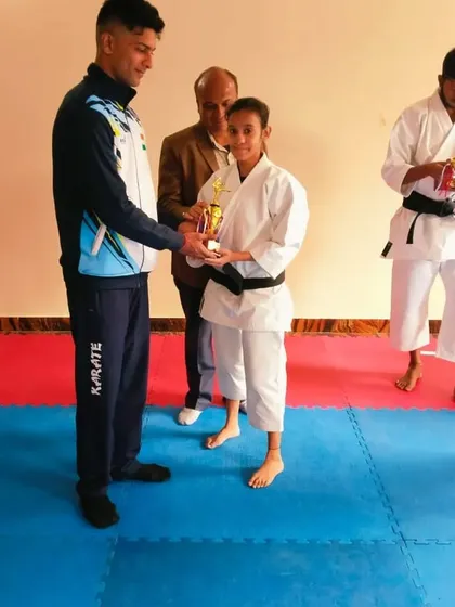 A female student receives her award for best kumite performance during the black belt grading.