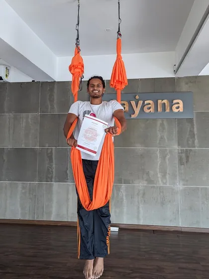 A newly certified aerialist proudly holds his certificate, ready to take flight on his teaching journey.