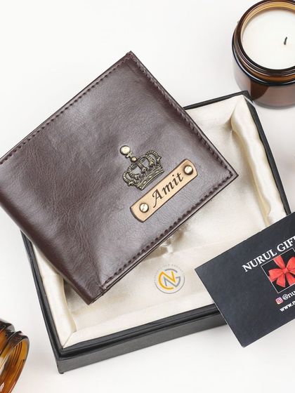 A classic brown leather wallet personalized with a crown charm, elegantly displayed in its gift box.