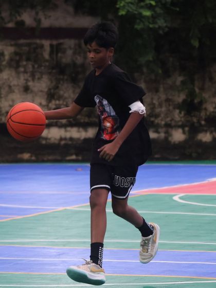 Dribbling with purpose. This player is working on his ball control while moving, a fundamental skill for any aspiring basketball player.