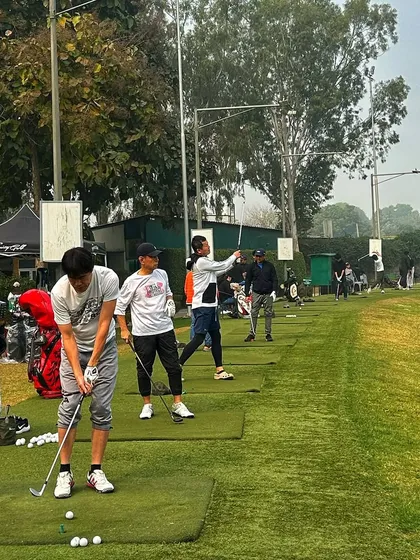 A full range of golfers, with some in mid-swing, creating a dynamic action shot.