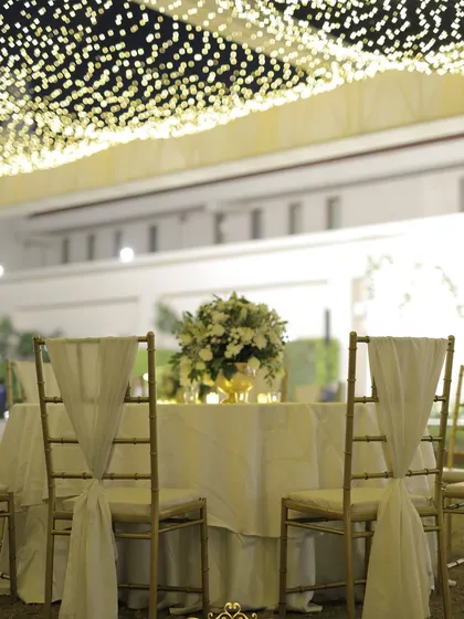 A detail of the guest seating under the starry night ceiling. The simple, elegant table setup allows the lighting to be the main feature.