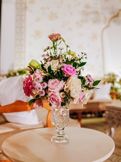 A beautiful bouquet of pink and white roses in a crystal vase, placed on a side table in the lounge. These small floral touches add softness and romance to the space.