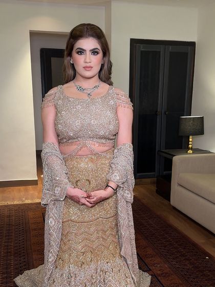 A full-length view of the client's sagan look. The glamorous makeup perfectly complements her embellished gold outfit.