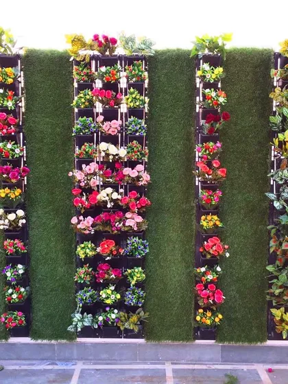 For this client's terrace, I designed a unique artificial garden combining a grass wall with vertical panels of colorful flowers. This creates a structured, modern look that is completely weatherproof.