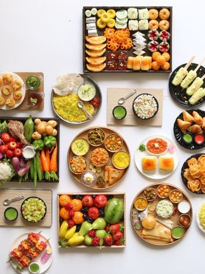 A large flat lay of recent orders, showing the incredible variety of miniatures I create, from fruits and vegetables to full meals.