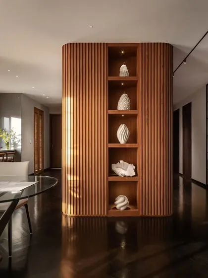 In the 'Rambagh' residence, we used curved, fluted wood panelling to create a warm, enveloping core that separates living areas while maintaining an open feel. This structure doubles as a display for curated art, reflecting our focus on integrating bespoke architectural elements that are both functional and beautiful.