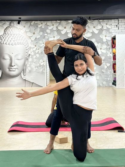 I am helping a student achieve a beautiful standing split variation. This partner-assisted stretch enhances balance and dramatically improves flexibility in the hamstrings and hips.
