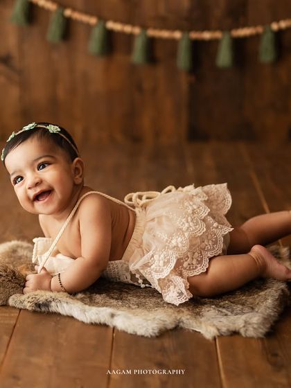 Priceless smiles. This baby is enjoying some tummy time on a soft fur rug, a great pose for younger sitters who are still building their strength.