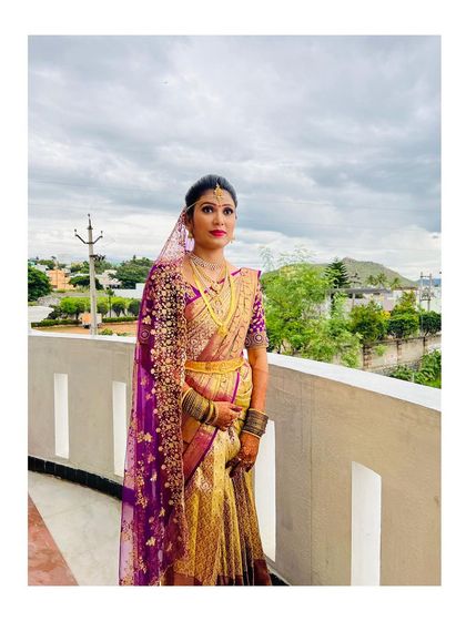 This bride's complete muhurtham look, with her richly embroidered purple veil and gold Kanjeevaram saree. The makeup is balanced to enhance her features without overpowering her natural beauty.