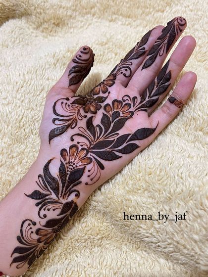 A bold Arabic floral design covering the palm. This style uses a mix of thick and thin lines with shaded petals and leaves to create a dramatic, eye catching look.