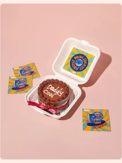 A "Daddy Cool" themed bento cake for Father's Day, shot against a clean pink background. This minimalist style puts the focus squarely on the fun and unique product.
