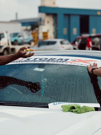 Build. Race. Repeat. Two team members apply decals and prep their car for the race. This dedication is the foundation of the competitive spirit at Vroom.