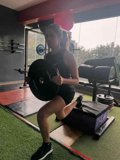Recovery and performance go hand in hand. Here, a client performs a weighted Bulgarian split squat, a key corrective exercise for building single-leg stability, glute strength, and correcting muscular imbalances that often lead to injury.