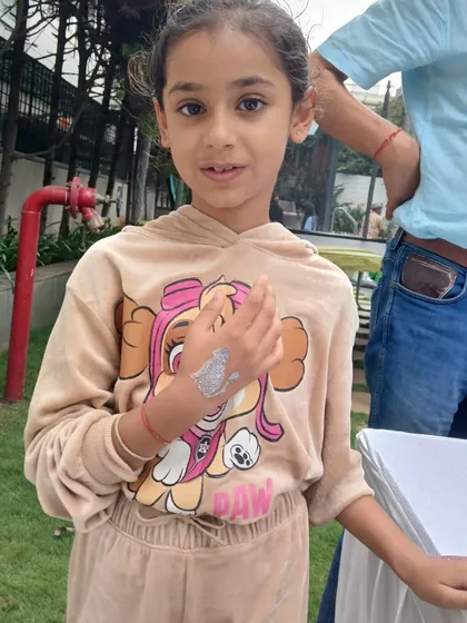 This guest is happy with her new silver glitter tattoo, which complements her Paw Patrol hoodie. I can create designs to match any character or party theme.