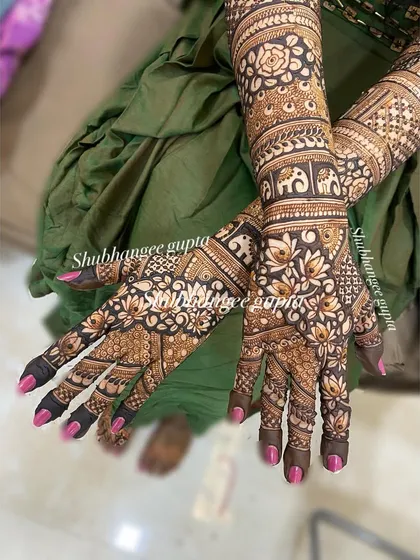 A detailed back-of-hand design for a bride, featuring rows of elephants and lotus flowers. The dense patterns ensure your hands look beautiful from every angle.