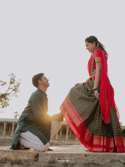 A romantic pose with the groom kneeling before his bride on the temple steps, bathed in the golden light of sunset.