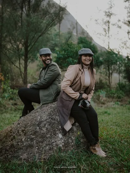 A happy, relaxed portrait of the couple sitting on a rock, their smiles capturing the joy of their pre-wedding adventure.