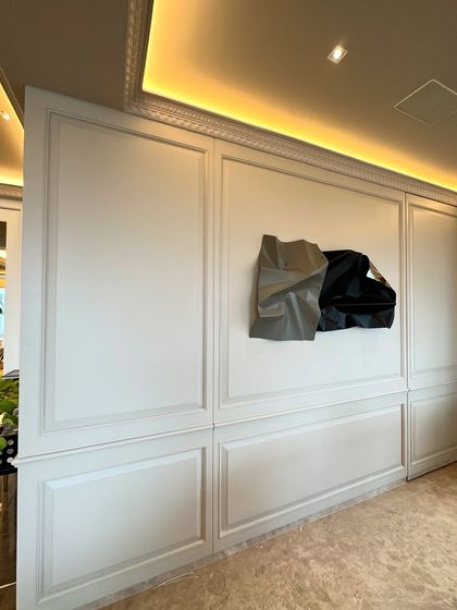 Another view of the dining room by Sarjita Raiyani, showing the sculpture on the paneled wall.