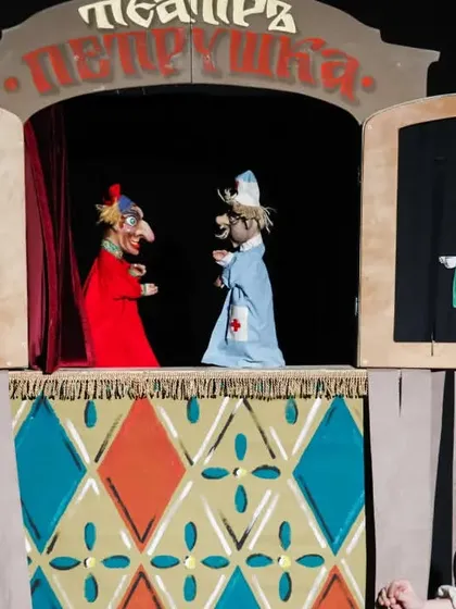 Petrushka interacts with the doctor in a classic slapstick vignette. The show is presented as a series of short, comic scenes.