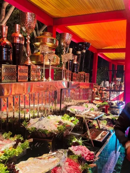 A vibrant and colorful salad bar setup for a festive night event. The counter is filled with a wide variety of fresh vegetarian salads and cold appetizers, beautifully arranged for guests to enjoy.