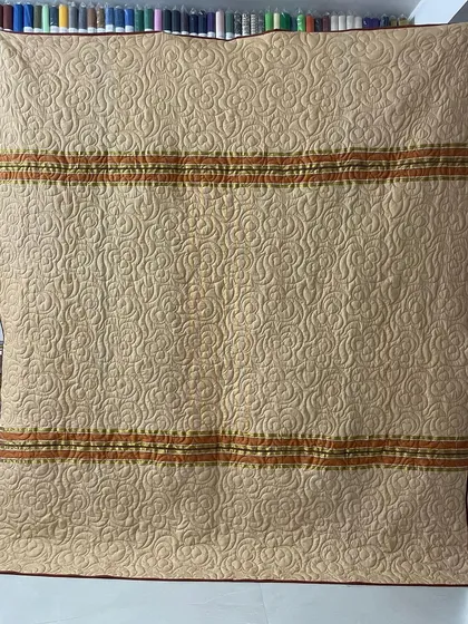 The alternate side of the orange saree quilt, showing a lovely beige fabric with delicate border details.
