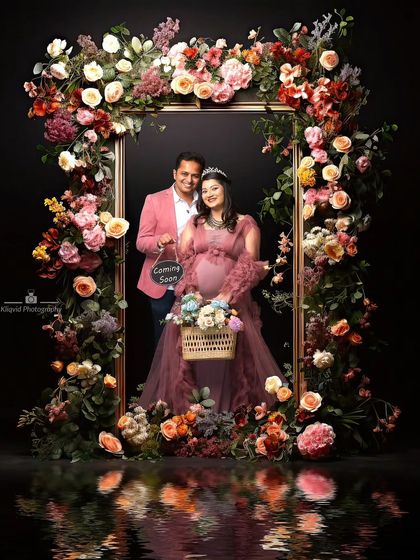 Framed by flowers, this couple shares their "Coming Soon" announcement. The setup symbolizes the bloom of love and the beautiful life they are creating together.