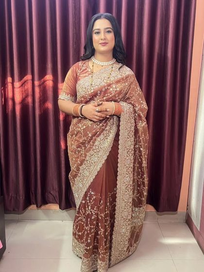 A full-length shot of the beautiful embroidered saree. The makeup is soft and sophisticated, perfectly complementing the elegant outfit.
