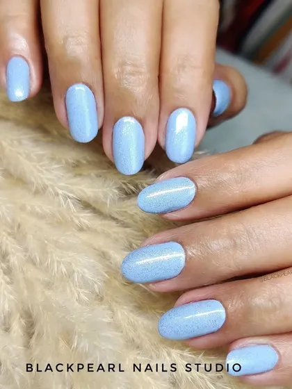 This set demonstrates the flawless fusion of a Russian Manicure for perfect cuticles and a BIAB overlay for strength. The light blue glitter gel polish adds a touch of sparkle to the durable and beautifully shaped nails.