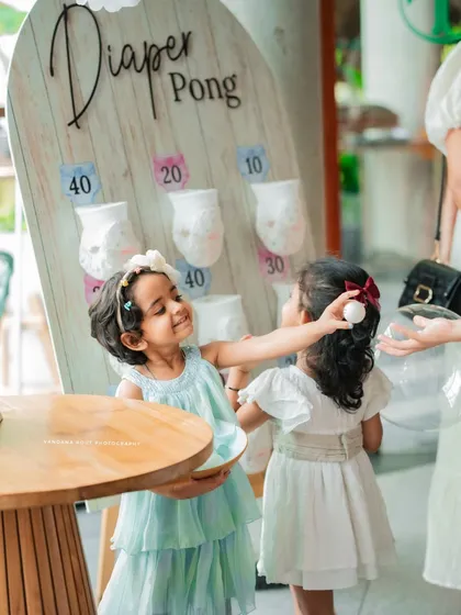 Capturing the fun and games at a baby shower, like this adorable 'Diaper Pong' moment between two young guests. It's these candid interactions that bring the story of your event to life.
