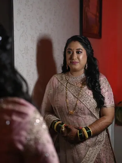 A moment of reflection. The bride looks into the mirror, admiring her final reception look, which is a perfect blend of modern style and timeless beauty.