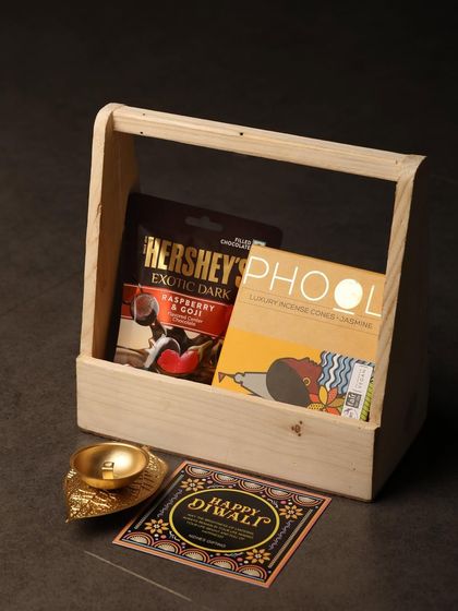 This simple and elegant gift set in a wooden tray is perfect for a minimalist aesthetic. It includes a bar of Hershey's dark chocolate, Phool incense cones, and a decorative shankh diya.