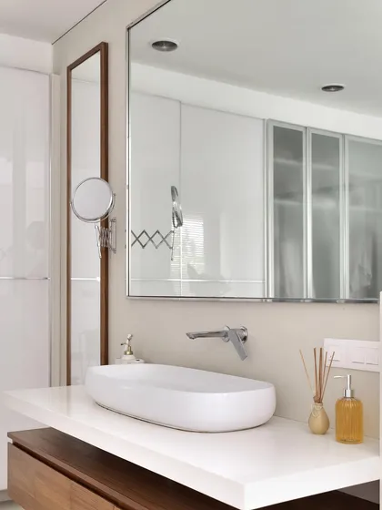 Another detail of the master bath, showing the large vanity mirror and a smaller, extendable makeup mirror.