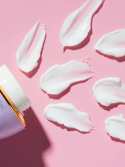 Product texture is a story in itself. This styled flatlay showcases the rich, creamy texture of a skincare product against a vibrant, clean background. The composition is intentional, designed to be both aesthetically pleasing and informative, giving customers a tactile sense of the product before they even touch it.