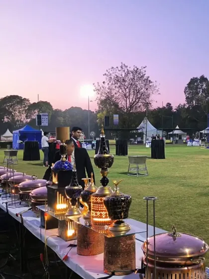 The warm glow of the setting sun over our expansive outdoor catering setup. This view captures the scale and beauty of the events we manage, ensuring a memorable experience from day to night.