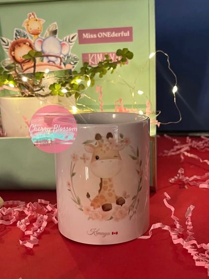 A beautifully customised jungle-themed mug, part of a luxury return gift set for a destination birthday. The fairy lights in the leatherette trunk add a magical touch to the final presentation.