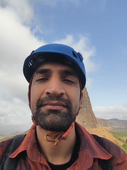 A selfie of Asim, a moment of quiet contemplation at the top of a climb with a stunning backdrop.
