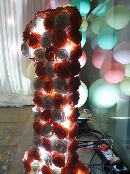 A close-up of a custom light-up marquee number, a popular feature for first birthday celebrations. This number '1' is decorated with artificial roses and internally lit, creating a beautiful and memorable centerpiece for photos.