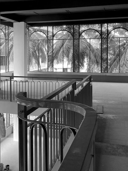 Another angle from the brewery site, focusing on the curved mezzanine railing and the large arched windows that will eventually frame views of palm trees, blending the industrial interior with the tropical exterior.