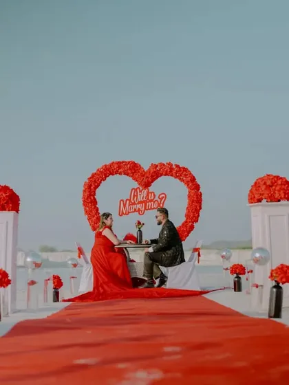 A grand proposal setup at the unique Kishangarh location. The red carpet, floral heart, and "Will you Marry me?" sign create an unforgettable and highly photogenic moment.