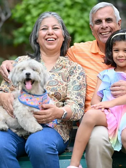 A beautiful moment of pure joy shared between grandparents, their grandchild, and their furry family member during a relaxed outdoor session in a Gurgaon park.